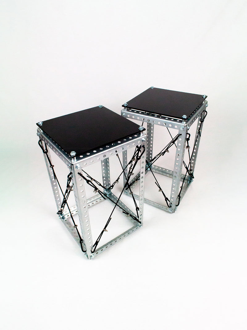 Side Table Set DP-001 pair shown at an angle, revealing the Diagrid steel frame's crossed cable bracing and black tabletops