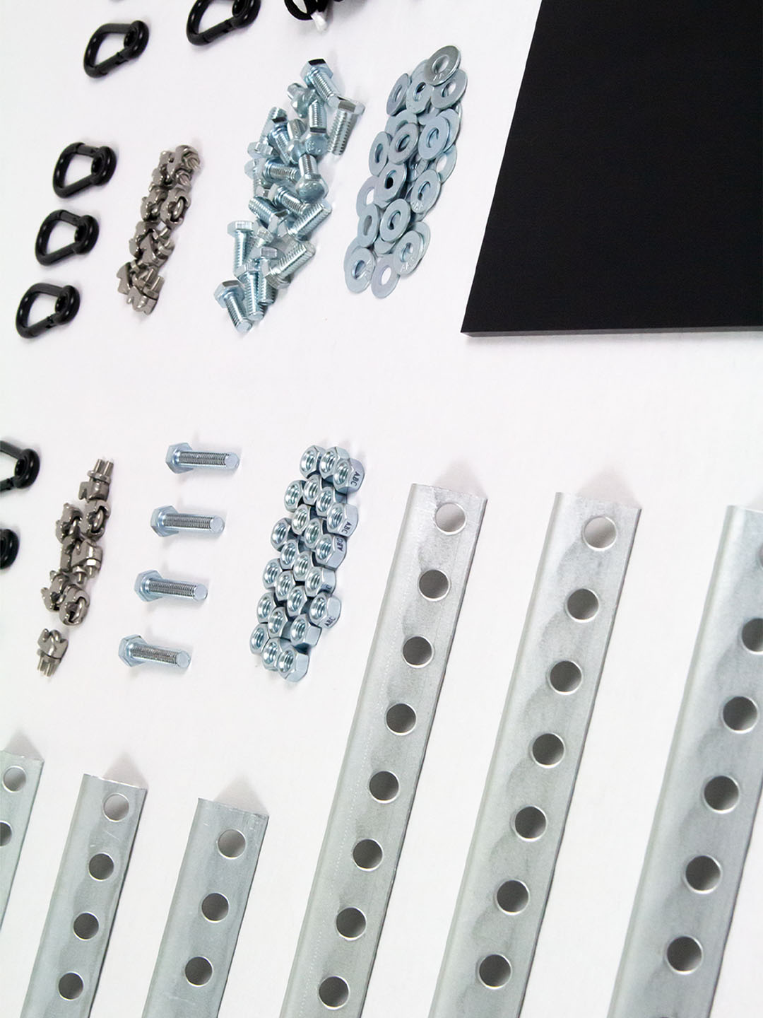 Flat-lay of Side Table Set DP-001 components — perforated steel frame rails, bolts, nuts, washers, and black acrylic top before assembly